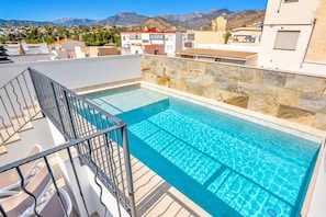 Ein Dachpool mit freiem Blick auf die umliegenden Gebäude und Berge.