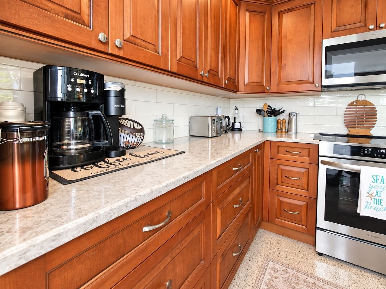 A kitchen with wooden cabinets, a coffee maker, a toaster, and a refrigerator.