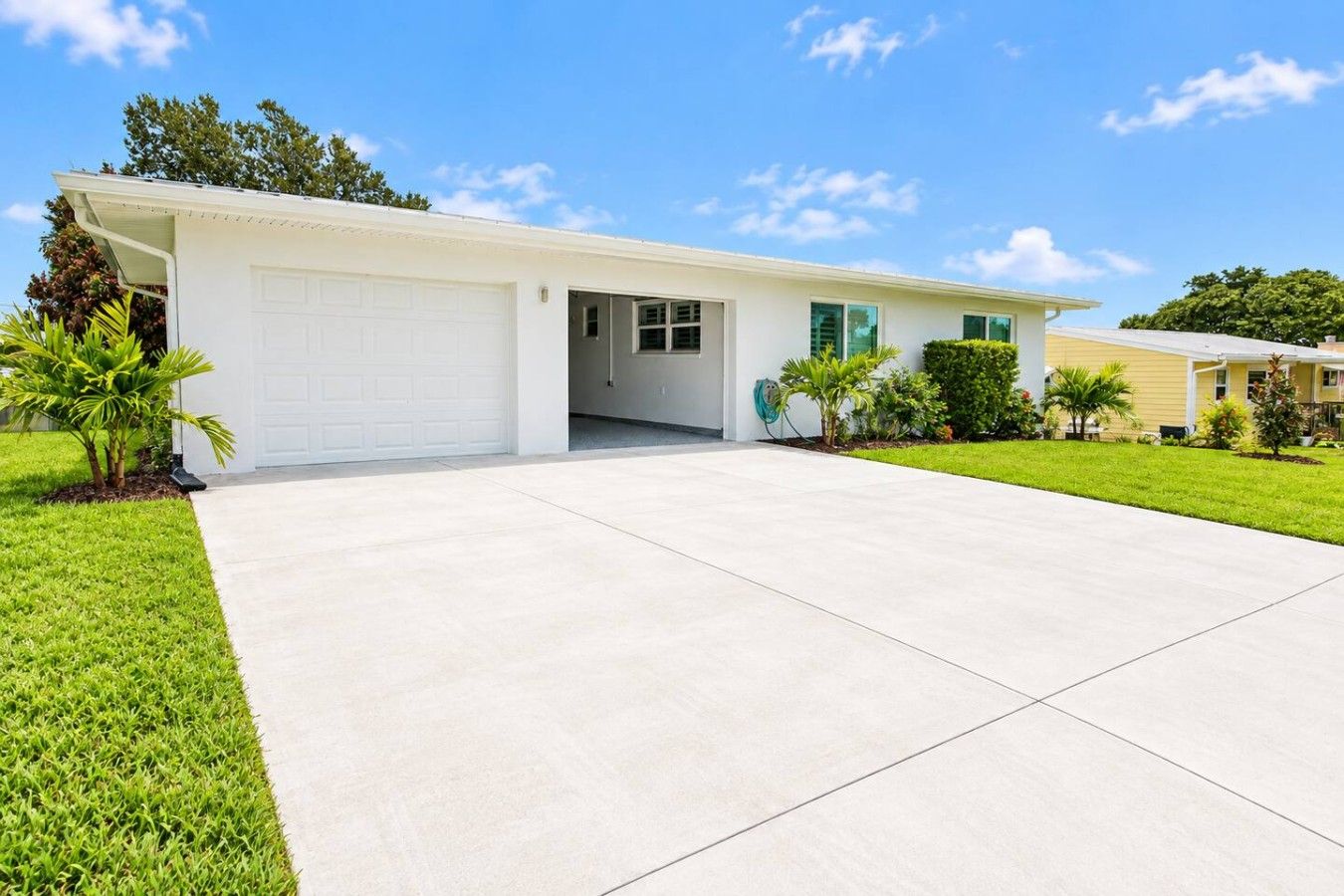 A single-story house with a garage, a front lawn, and a clear sky.