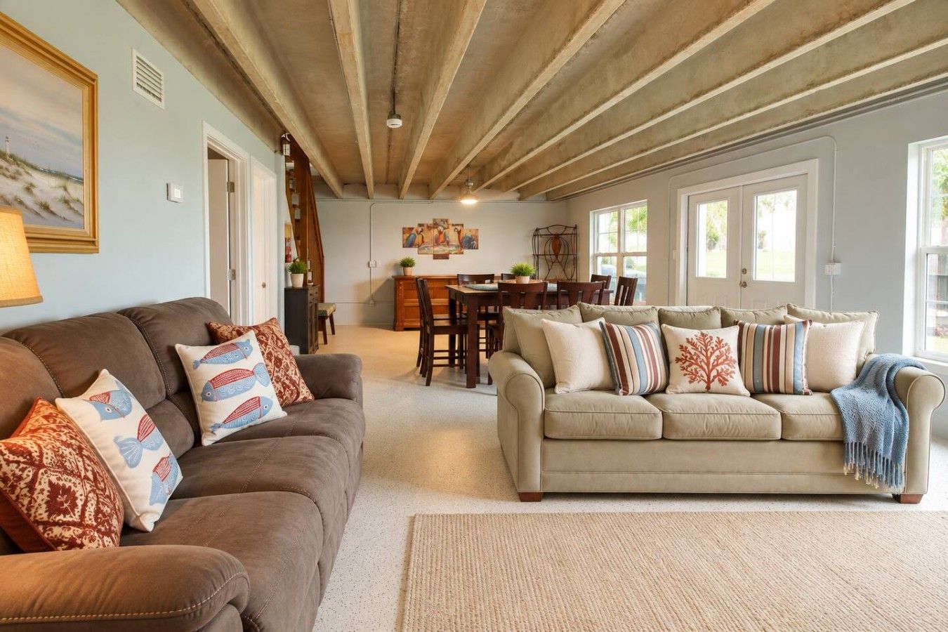 Ein Wohnzimmer mit zwei Sofas, einem Essbereich und einer Küche im Hintergrund.