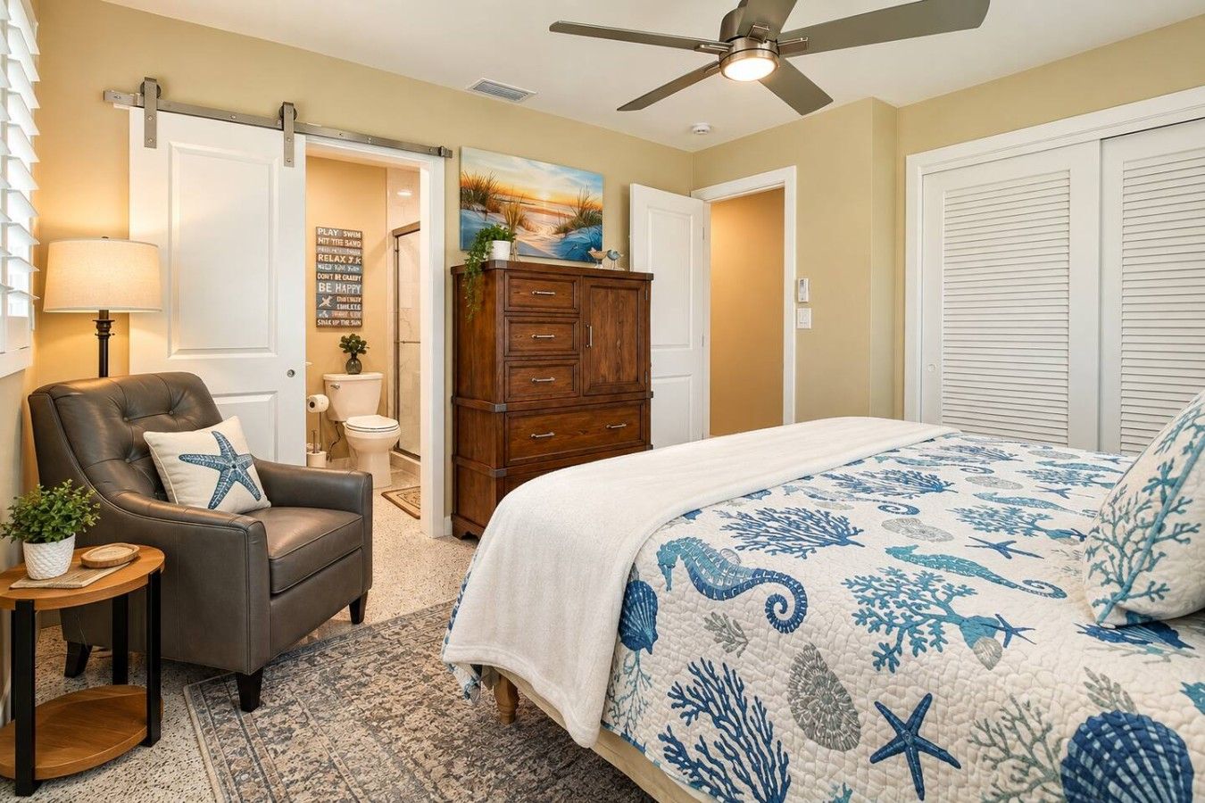 A bedroom with a bed, a chair, a dresser, and a ceiling fan.