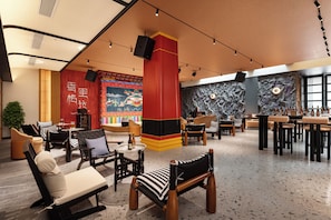 A modern lounge area with seating arrangements, a bar, and decorative elements. - LIAN HOTEL (Deqin)
