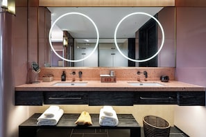 A modern bathroom with a double sink vanity, a large mirror with circular lighting, and two towels on the counter. - LIAN HOTEL (Deqin)
