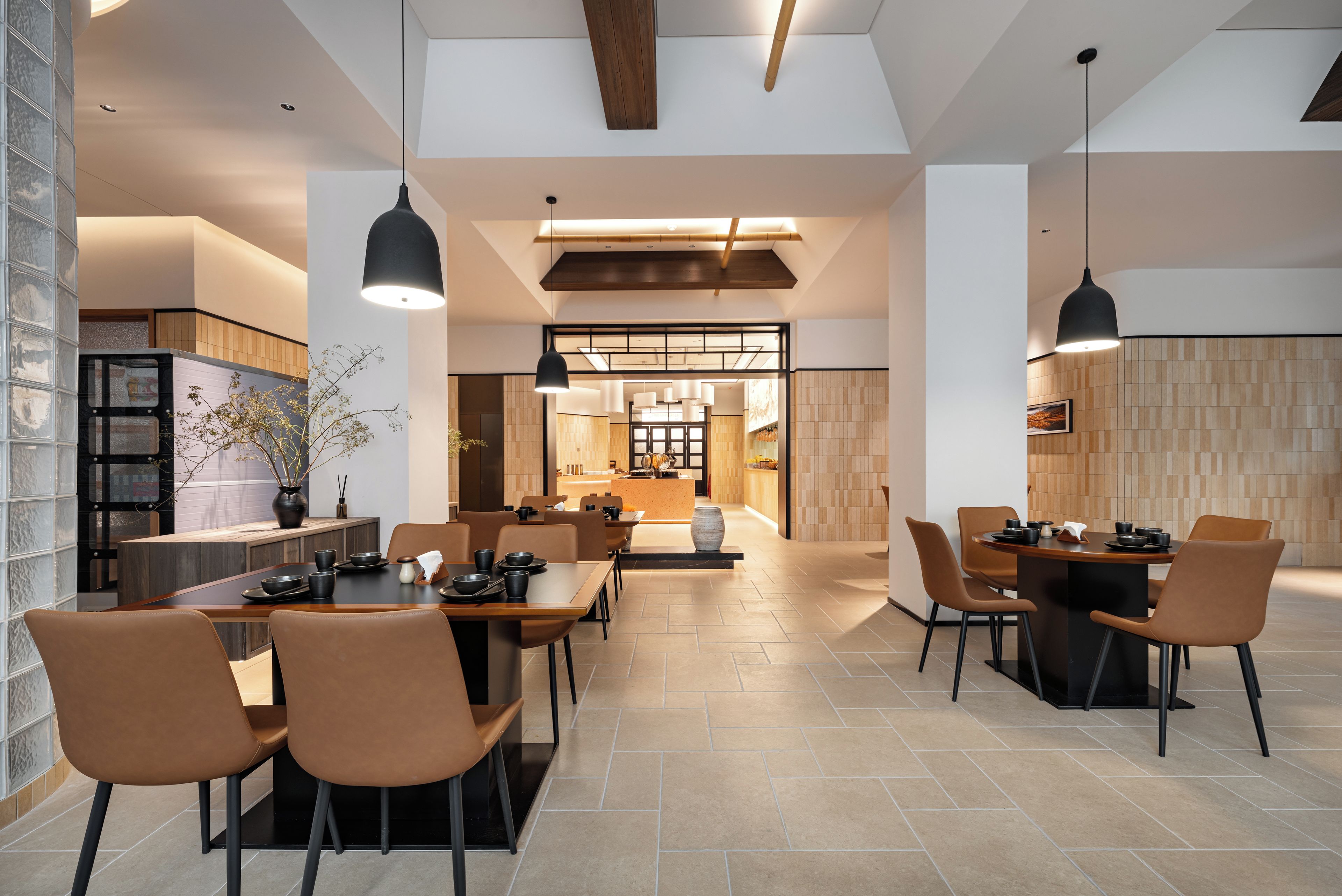 A spacious dining area with high ceilings and modern pendant lighting.
