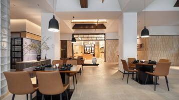 A spacious dining area with high ceilings and modern pendant lighting.