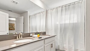 A bathroom with a double sink, a large mirror, and a shower curtain. - ChampionsGate Home: Pool, Disney 15min, Sleeps 13 (Kissimmee)
