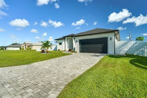 En bostadsfastighet med en asfalterad uppfart, ett garage och en välskött gräsmatta.
