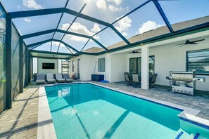 An indoor swimming pool with a glass ceiling, lounge chairs, and a barbecue area. - Private Pool & Fun-Filled 4BR Cape Coral Retreat (Cape Coral)