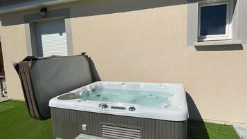 Uma casa com hidromassagem coberta e um pequeno alpendre.