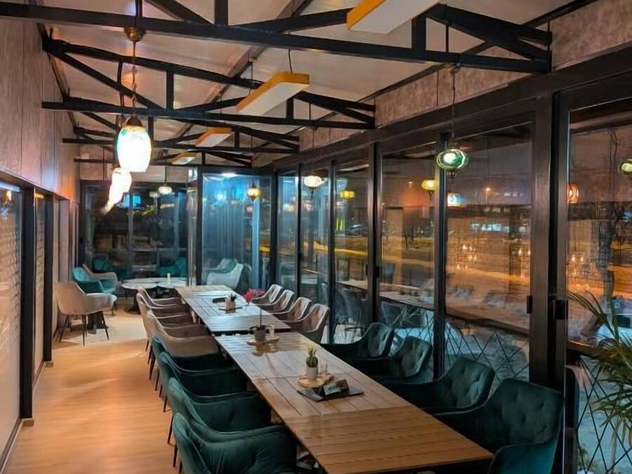 A conference room with a long table, chairs, and a view through large windows.