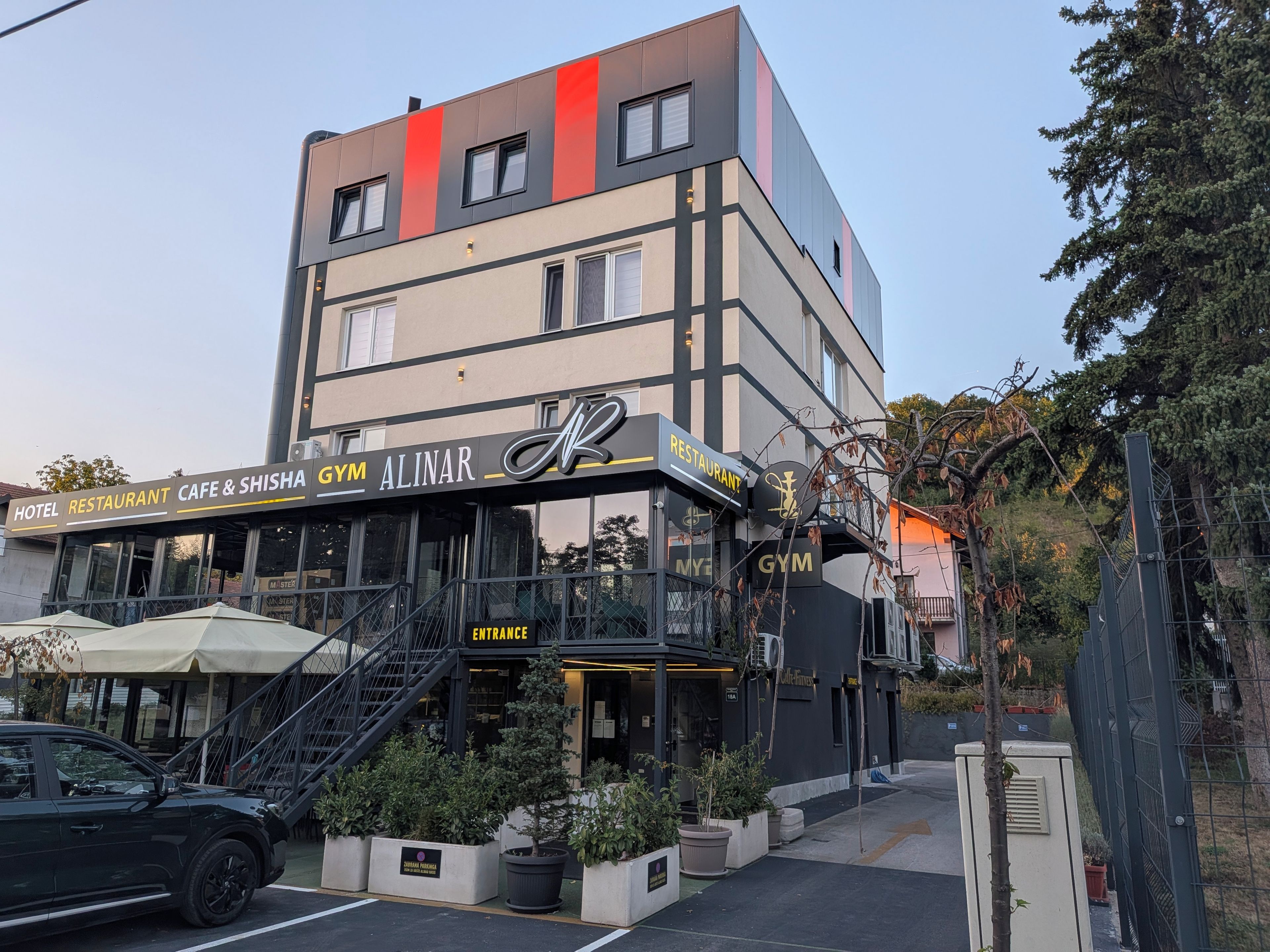 Un edificio de varios pisos con gimnasio, restaurante y cafetería.