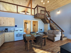 A spacious kitchen with wooden cabinets, a stove, and a dining area with a table and chairs. - Remote 2 bedrooms cabin (La Sal)