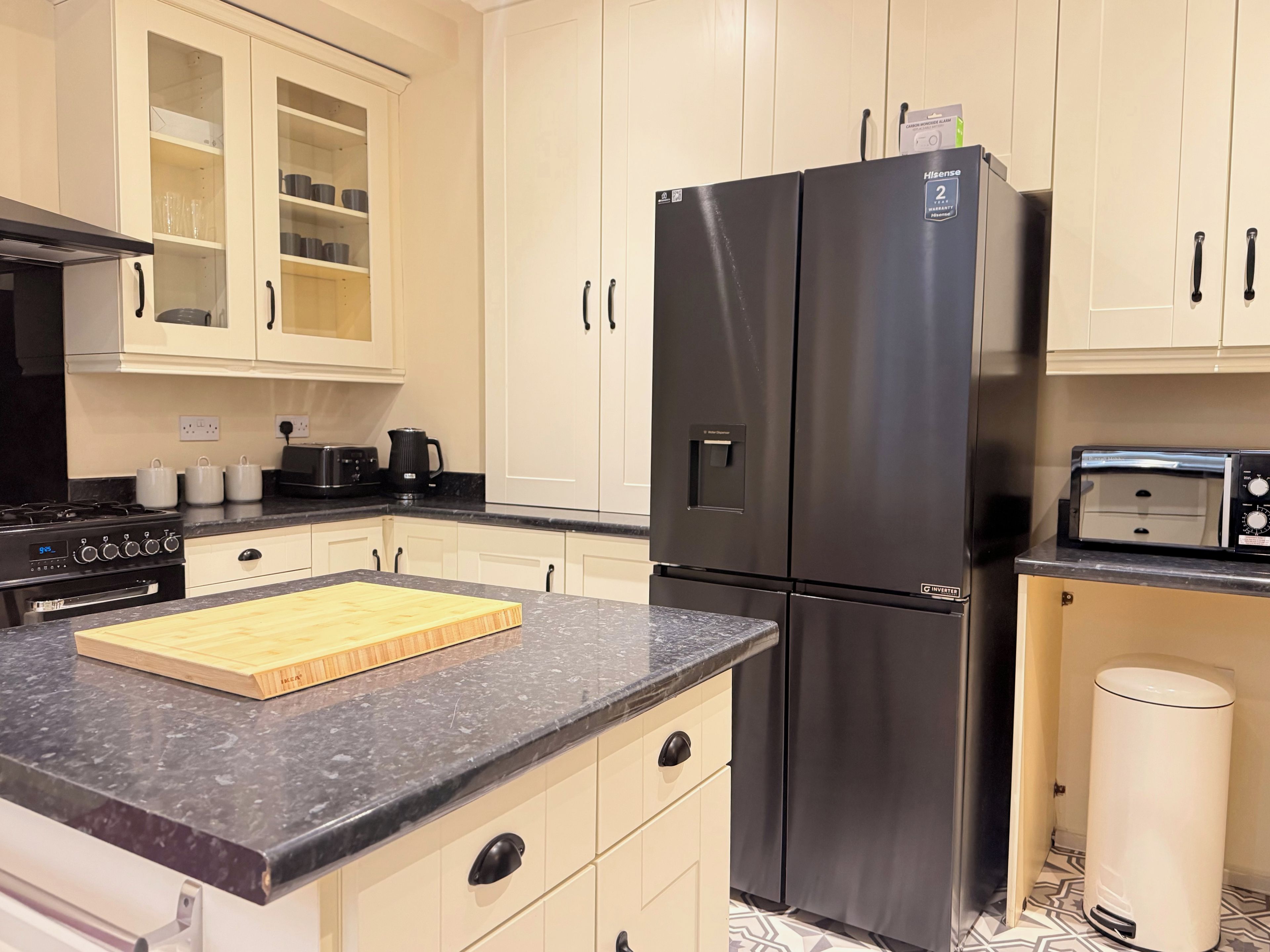 Una cocina con un refrigerador negro, un tostador y una cafetera.