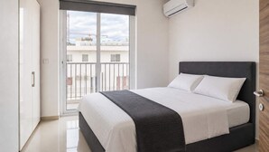 A bedroom with a bed, a window, and an air conditioning unit. - Sea Views & Terrace - 2BR Penthouse, St Julian's (San Ġiljan)