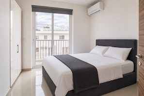 A bedroom with a bed, a window, and an air conditioning unit. - Sea Views & Terrace - 2BR Penthouse, St Julian's (San Ġiljan)