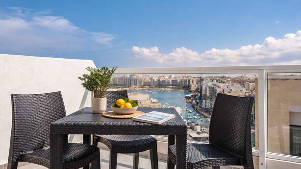 A balcony with wicker furniture, a bowl of lemons, and a potted plant. - Sea Views & Terrace - 2BR Penthouse, St Julian's (San Ġiljan)
