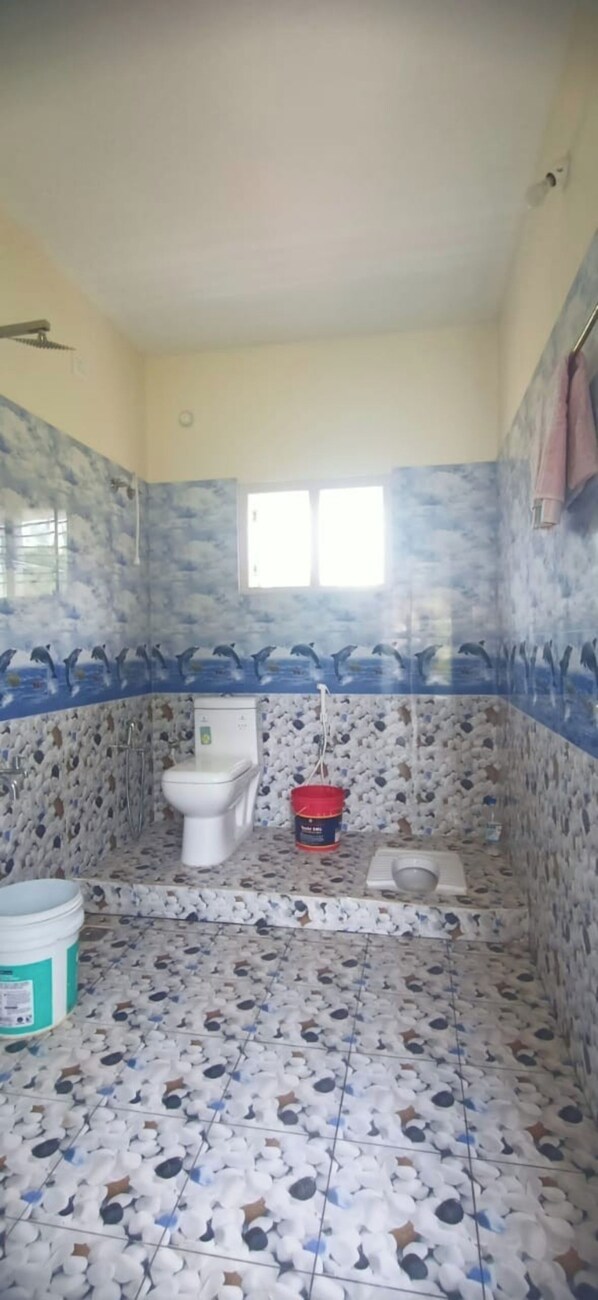 A bathroom with a toilet, bidet, and shower area.