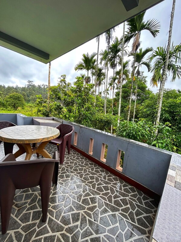 A covered outdoor area with a tiled floor, a round table, and two chairs.