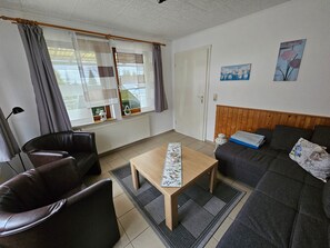A furnished living room with a sofa, a chair, a table, and a radiator. - Holiday Home Kretscham with Private Terrace and Garden (Sehmatal)