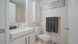 A bathroom with a white sink, toilet, and a towel hanging on the wall. - Bright 1Bedroom w/ Balcony Steps to CN Tower-MTCC (Toronto)