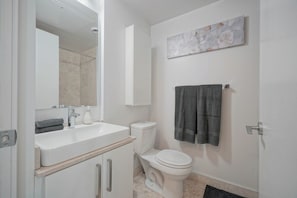 Ein Badezimmer mit Waschbecken, Toilette und einem Handtuch an der Wand.