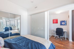 A bedroom with a bed, a desk, and a chair. There is a sliding door leading to a balcony. - Cozy Toronto Condo with CN Tower View & Workspace (Toronto)