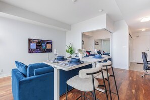 A modern living space with a dining area, a sofa, and a bar stool. - Cozy Toronto Condo with CN Tower View & Workspace (Toronto)