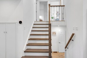 A staircase with wooden steps and a wooden handrail, leading to a landing with a door. - 5BR North York Home - Sleeps 11 - Parking (Toronto)