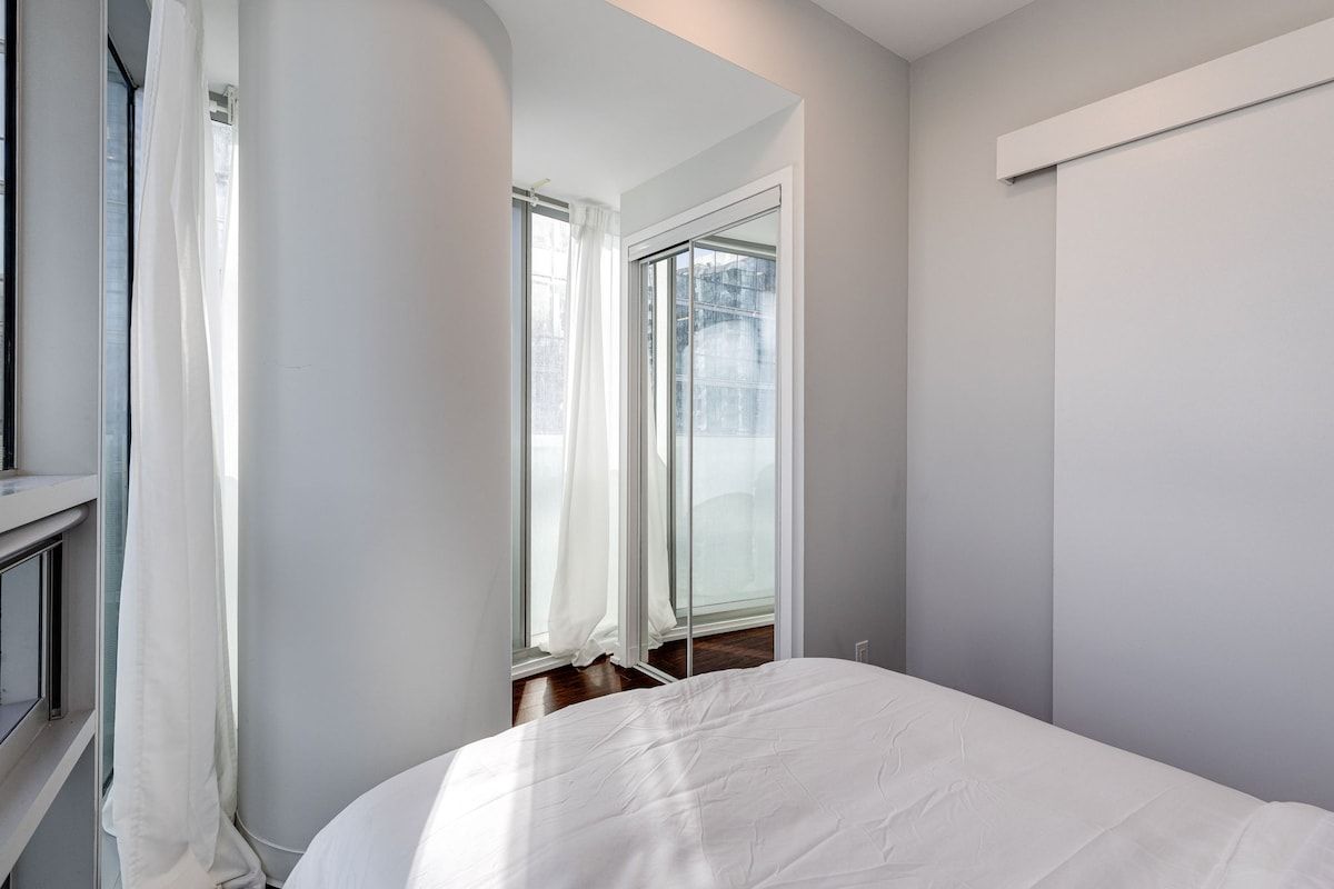 Ein Schlafzimmer mit einem Bett, einem Fenster und einer Tür.