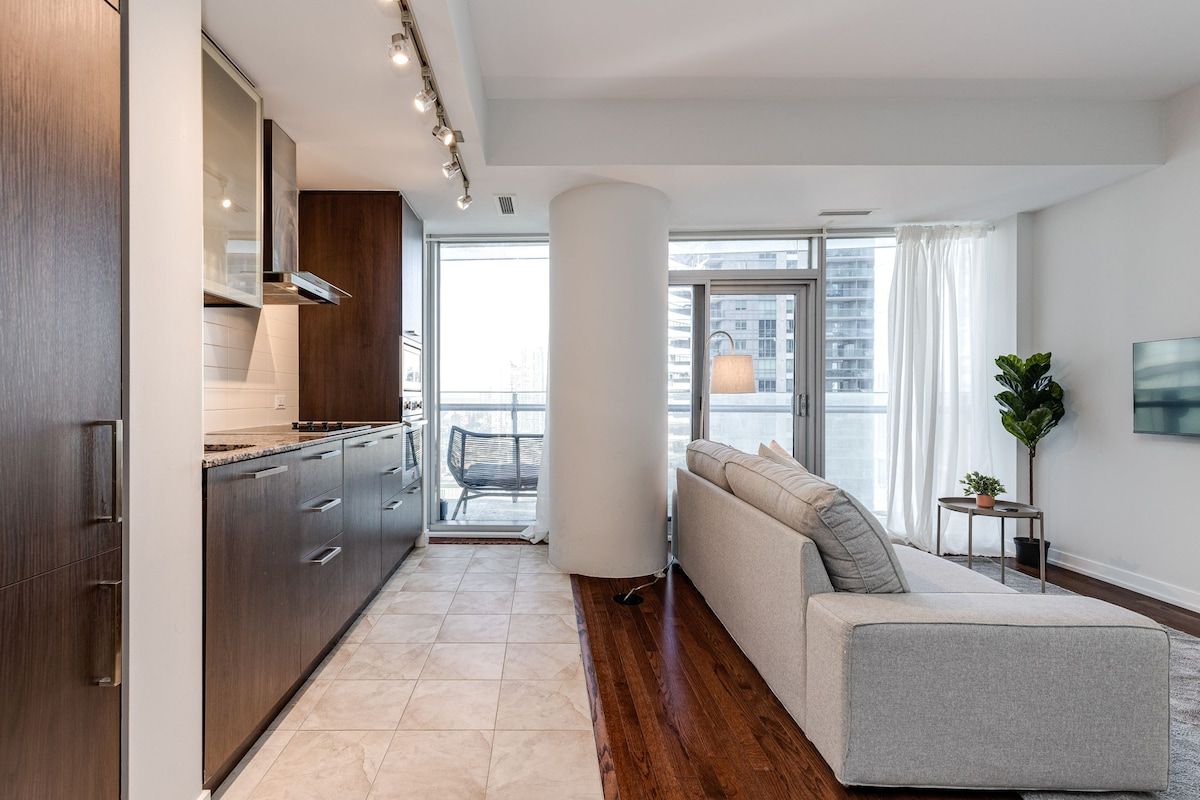 A modern apartment with a kitchen, a living area with a sofa, and a balcony.