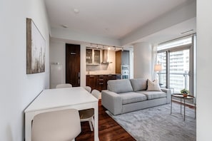 Ein modernes Apartment mit Essbereich, Sofa und Küchenzeile.