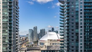 A high-rise building with a modern architectural design, featuring multiple balconies and large windows. - 2BR Condo w/ Stunning CN Tower View & Free Parking (Toronto)