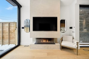 A modern living room with a fireplace, a flat-screen TV, and a sofa. - Luxury Toronto Home with Rooftop Terrace & Parking (Toronto)
