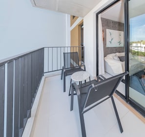A balcony with a black metal railing, a round table, and two chairs. - Corporate Stays First del Sol - 408 (Asunción)