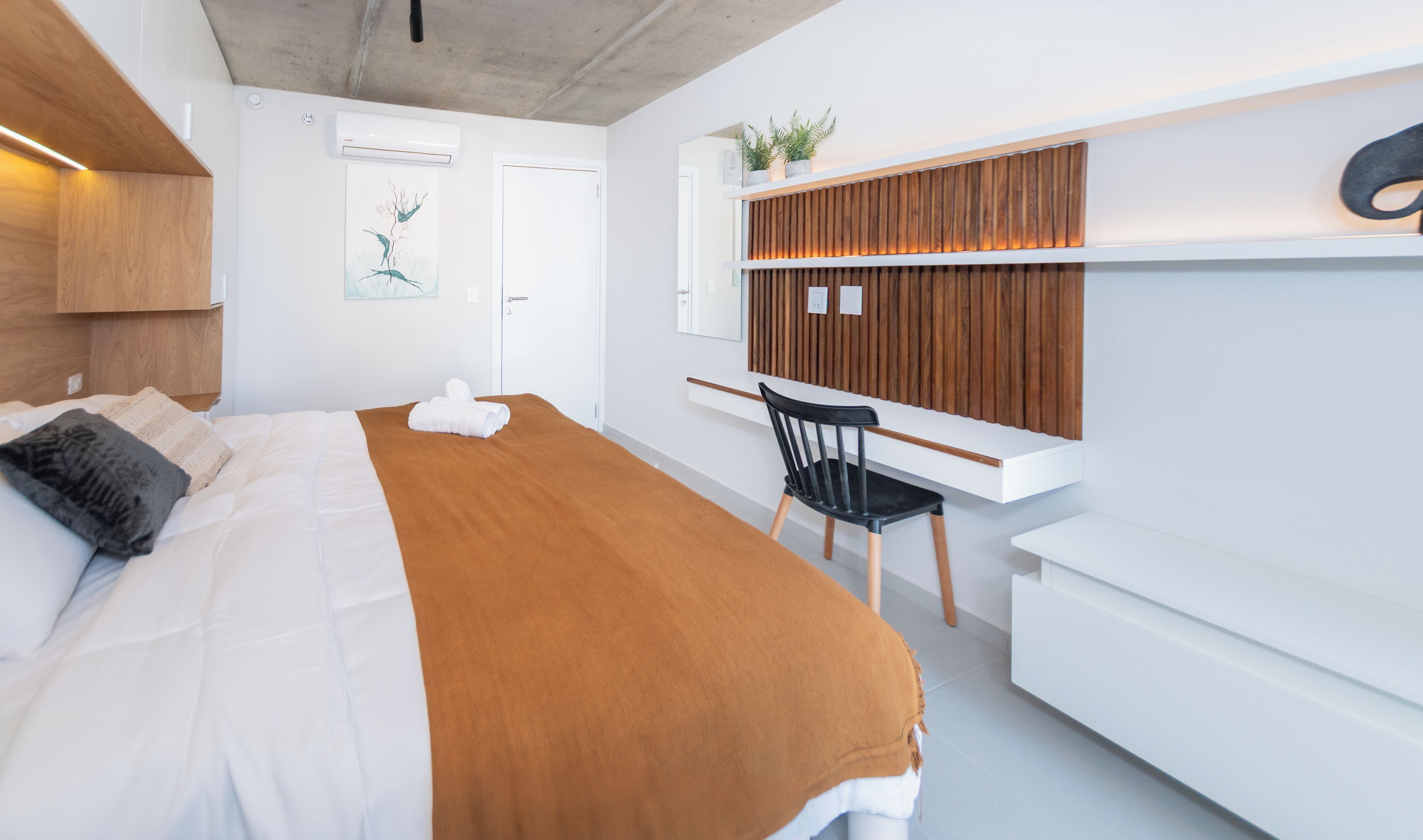 Una habitación de hotel moderna con una cama, un escritorio y una silla.