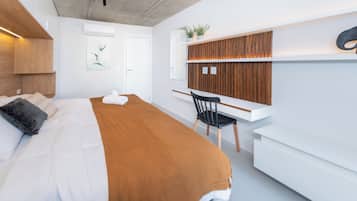 Una habitación de hotel moderna con una cama, un escritorio y una silla.