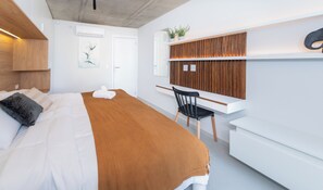 A modern hotel room with a bed, a desk, and a chair. - Corporate Stays First del Sol - 408 (Asunción)