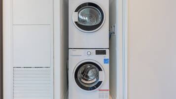 Two stacked front-loading washing machines in a laundry room.