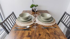 Et spisebord med et glas vand, to tallerkener og bestik.