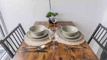 A dining table with a glass of water, two plates, and cutlery.