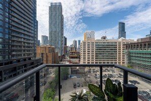 Un immeuble de grande hauteur offrant une vue sur le paysage urbain, avec d’autres immeubles hauts et un parking.