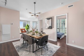 A modern dining area with a wooden table, chairs, and a ceiling fan. - Prime Location 3BR Condo Steps from CN Tower (Toronto)