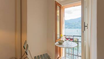 Ein kleiner Balkon mit Tisch, zwei Weingläsern und einer Schüssel mit Nüssen.