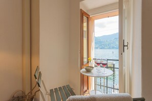 Ein kleiner Balkon mit Tisch, zwei Weingläsern und einer Schüssel mit Nüssen.