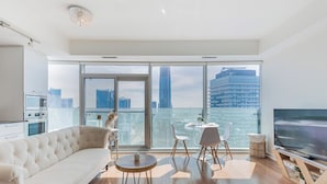 Een moderne woonkamer met een bank, een ronde tafel en een televisie.