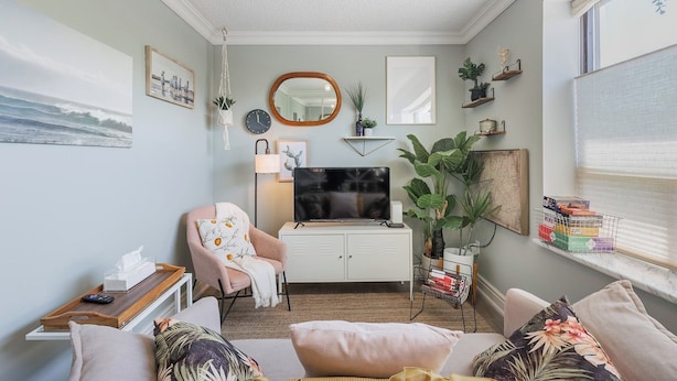 A cozy living room with a sofa, armchair, and a television on a cabinet. - Cozy 1BR Toronto Stay Near Transit & Dining (Toronto)