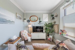 A cozy living room with a sofa, armchair, and a television on a cabinet. - Cozy 1BR Toronto Stay Near Transit & Dining (Toronto)