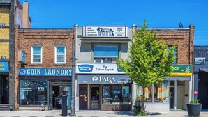 A street view with businesses including a coin laundry, a paint store, and a cafe. - Cozy 1BR Toronto Stay Near Transit & Dining (Toronto)