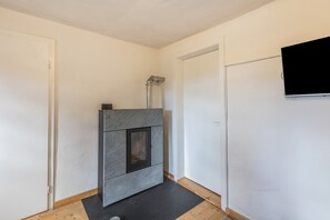 A modern bathroom with a built-in shower, a white door, and a mounted television.