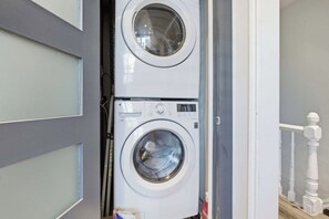 A laundry room with two stacked front-loading washing machines. - Spacious 4BR Toronto Stay Near U of T & Downtown (Toronto)
